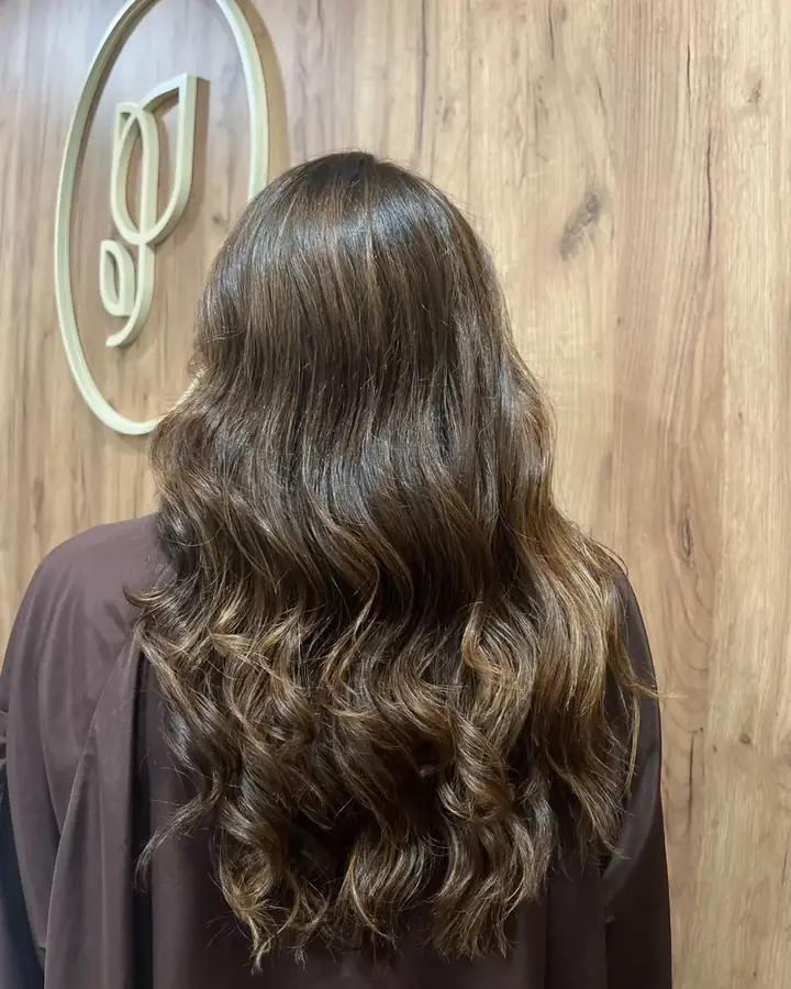 Melena castaña con ondas y brillo tras una coloración con barros